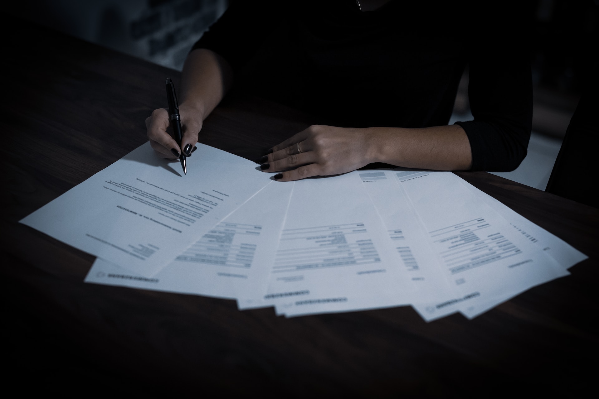 A woman signing many contracts